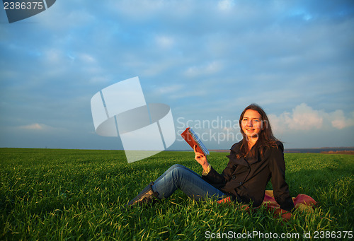 Image of Teen girl reading the Bible outdoors