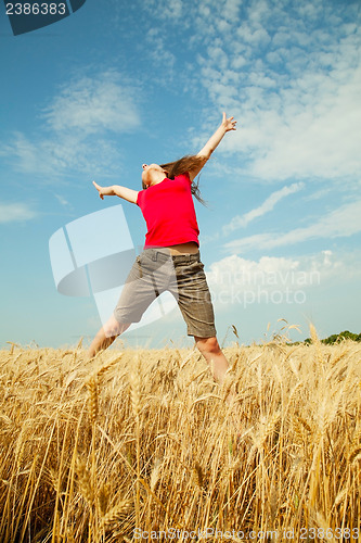 Image of Teen girl jumping at a wheat field