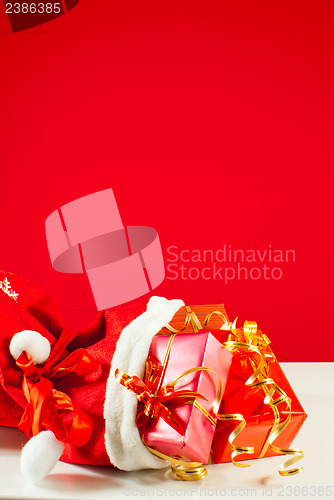Image of Christmas presents in the bag against red background
