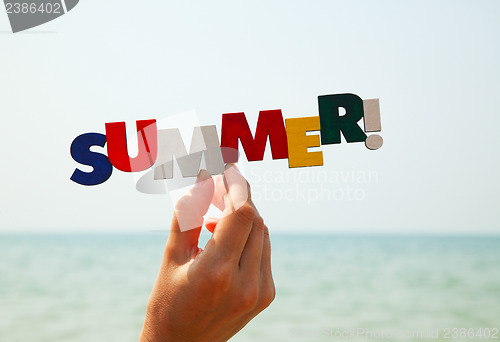 Image of Female's hand holding colorful word "Summer"