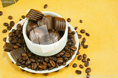Image of Cup full with coffee beans and chocolate candies