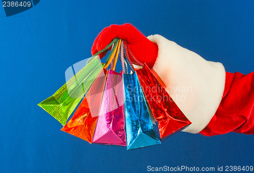 Image of Santa's hand holding colorful bags