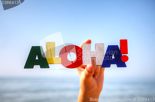 Image of Female's hand holding colorful word 'Aloha'