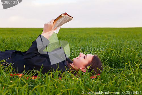 Image of Teen girl reading the Bible outdoors