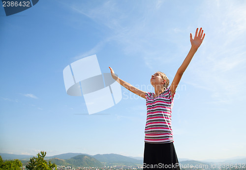 Image of Teenage girl staying with raised hands