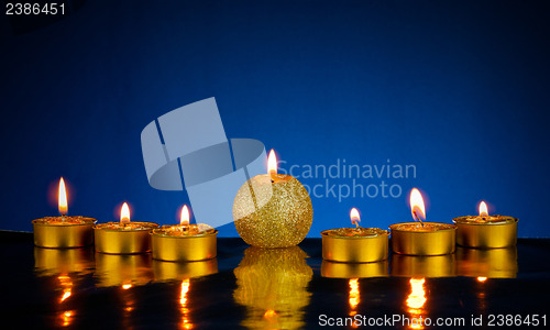 Image of Seven burning candles over blue background