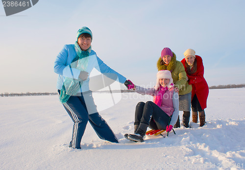 Image of Four happy ladies sledding at winter time