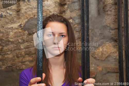 Image of Young woman behind the bars