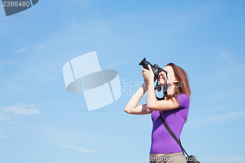 Image of Young lady photographer outdoors