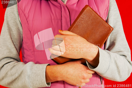 Image of Female holding a book with her hands