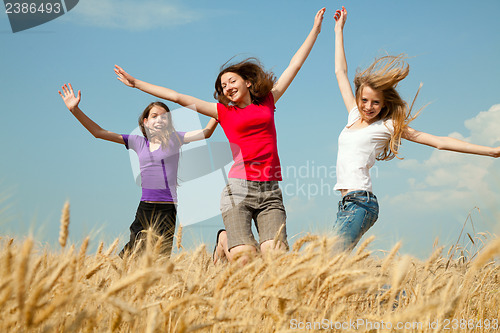 Image of Teen girl jumping at a wheat field