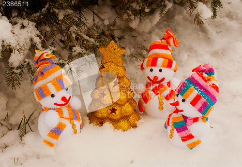 Image of Three snowmen with golden evergreen tree