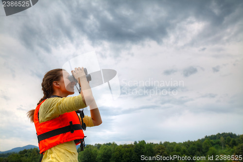 Image of Young woman looking through binoculars