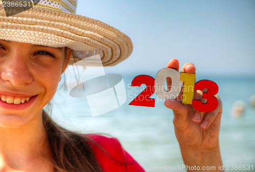 Image of Teen girl holding wooden number '2013'