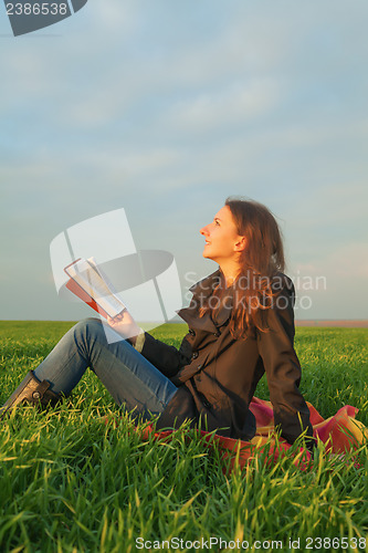 Image of Teen girl reading the Bible outdoors