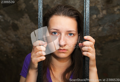 Image of Young woman behind the bars