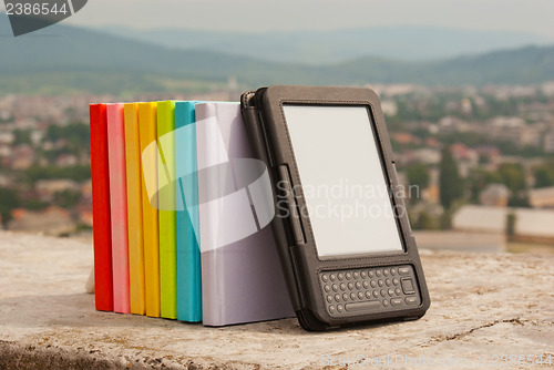 Image of Row of colorful books with electronic book reader