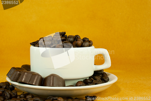 Image of Cup full with coffee beans and chocolate candies