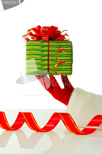 Image of Santa's hand holding a Christmas present against white backgroundSanta's hand holding a Christmas present against white background