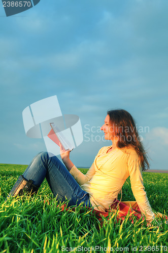 Image of Teen girl reading the Bible outdoors