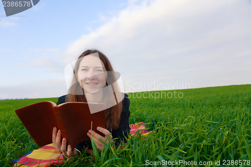 Image of Teen girl reading the Bible outdoors