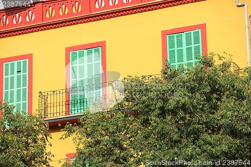 Image of Colourful yellow house with green shutters