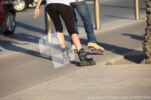 Image of People rollerblading down a sidewalk