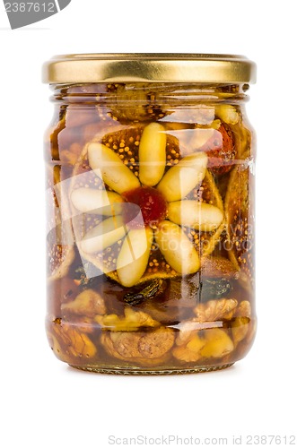 Image of Glass jar filled with honey, nuts and fruits