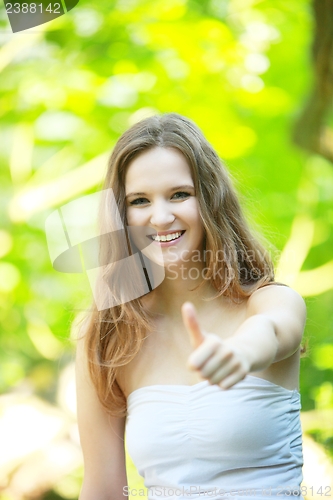 Image of Happy young woman giving a thumbs up