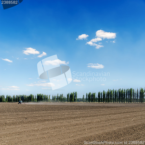 Image of black ploughed field under blue sky