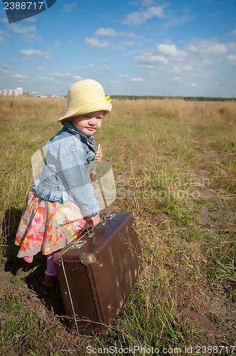 Image of lonely girl with suitcase. Back view