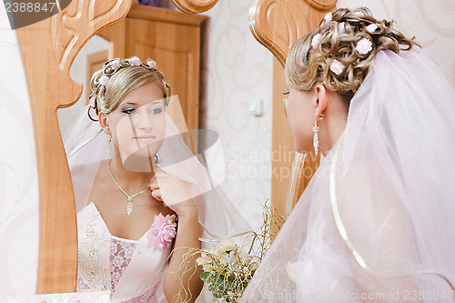 Image of bride looks in the mirror