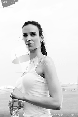 Image of Young beautiful woman drinking water after fitness exercise