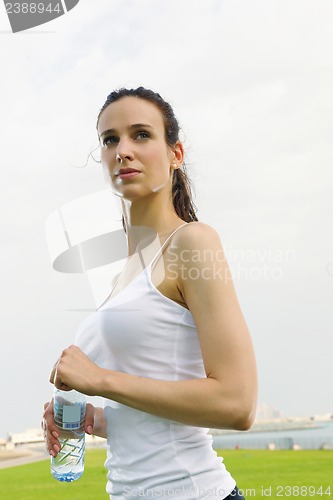 Image of Young beautiful woman drinking water after fitness exercise