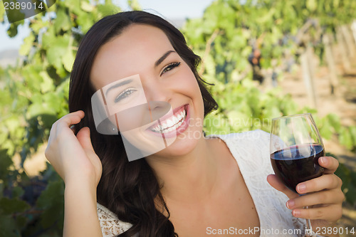 Image of Young Adult Woman Enjoying A Glass of Wine in Vineyard