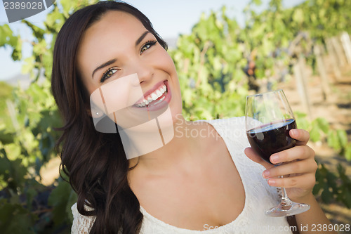 Image of Young Adult Woman Enjoying A Glass of Wine in Vineyard