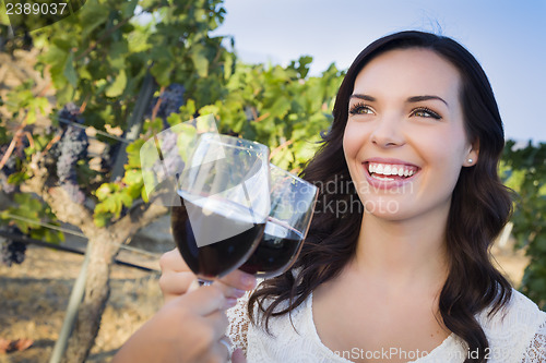 Image of Young Woman Enjoying Glass of Wine in Vineyard With Friends