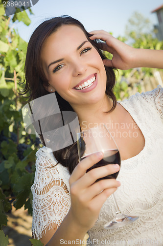 Image of Young Adult Woman Enjoying A Glass of Wine in Vineyard