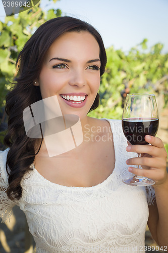 Image of Young Adult Woman Enjoying A Glass of Wine in Vineyard