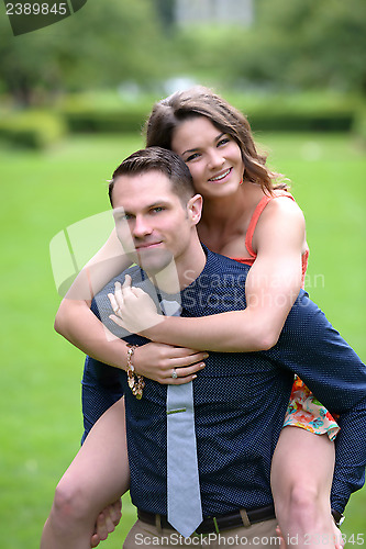 Image of Handsome young man carrying his fiance on his back