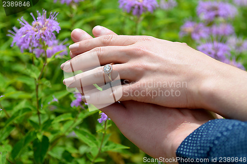 Image of Young woman's hand resting on her fiance's showing the engagemen