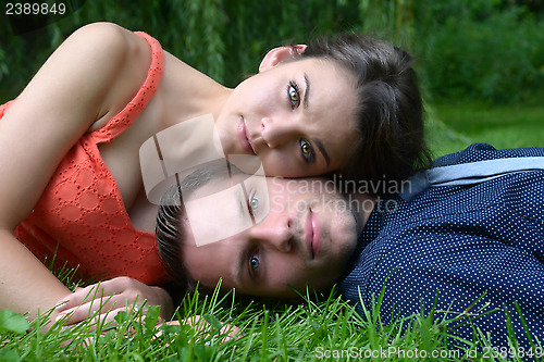 Image of Young couple laying on the grass with the woman's head resting o