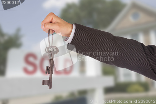 Image of Man in suit giving old keys