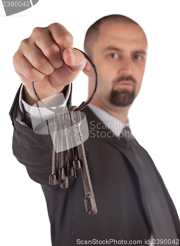 Image of Man in suit giving old keys to a house