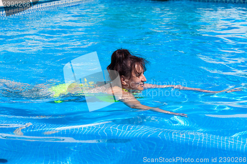 Image of Middle-aged woman swims in the swimming pool