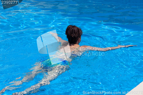 Image of Middle-aged woman swims in the swimming pool