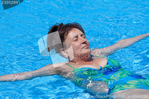 Image of Middle-aged woman swims in the swimming pool