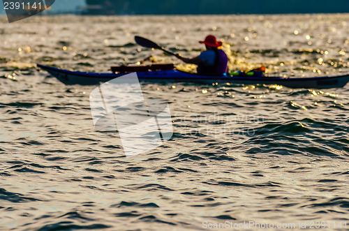 Image of Sillouette of man kayaking on lake