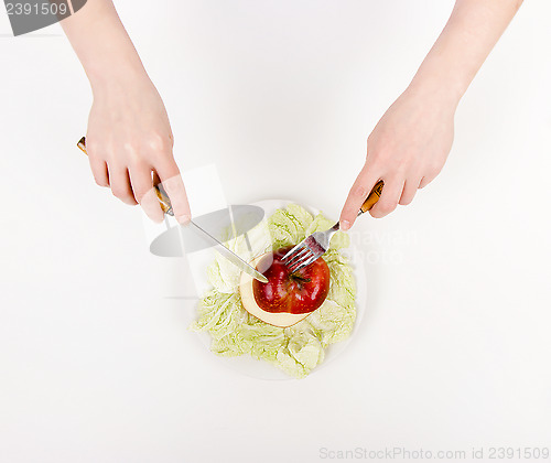 Image of Women's hands with knife and fork on a plate