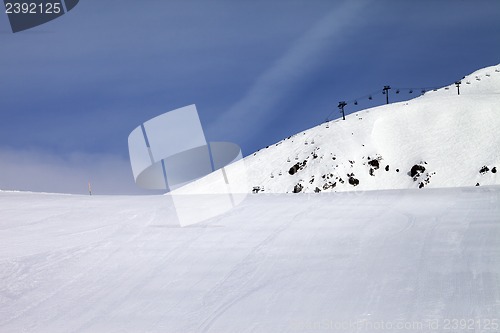 Image of Ski slope and chair-lift against blue sky